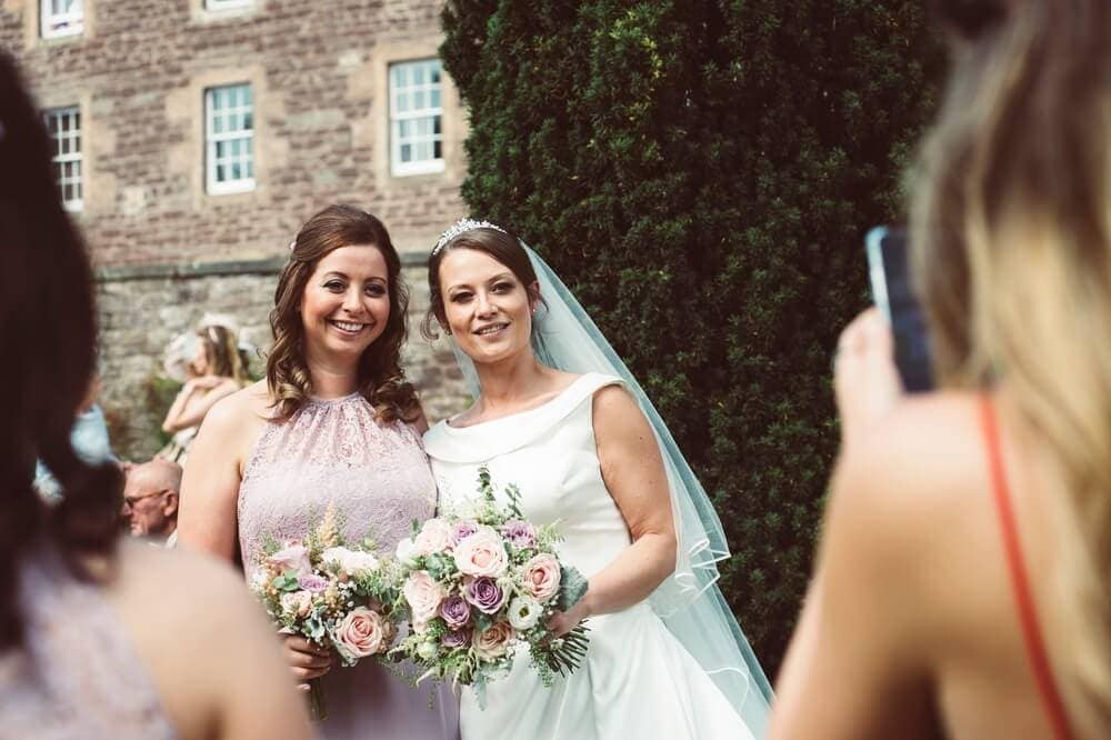 Candid wedding photography of bride and bridesmaid at New Lanark by Glasgow Wedding Photographer Richard Campbell