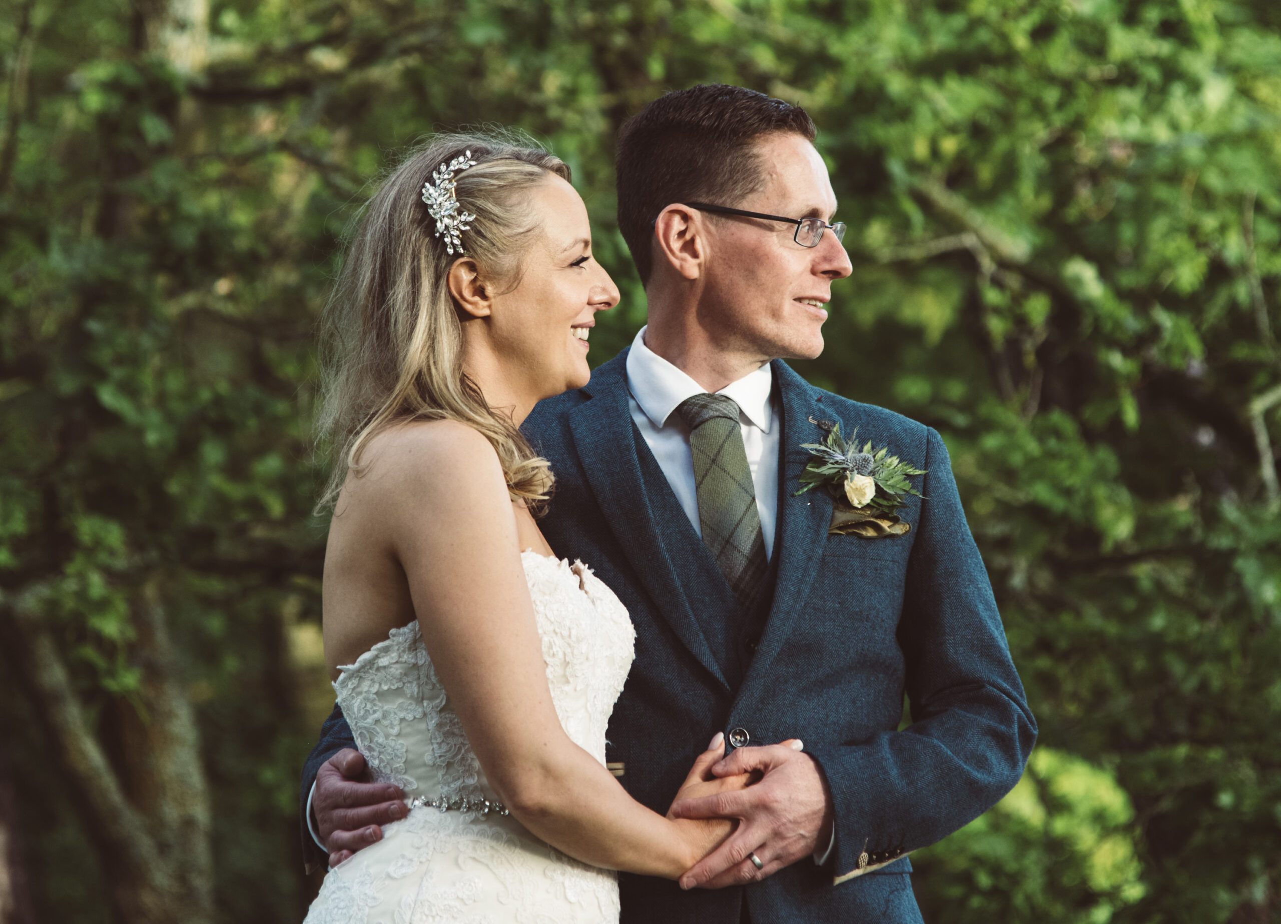Bride and groom standing framed by trees at the Lochgreen House Hotel by Ayrshire wedding photographer Richard Campbell