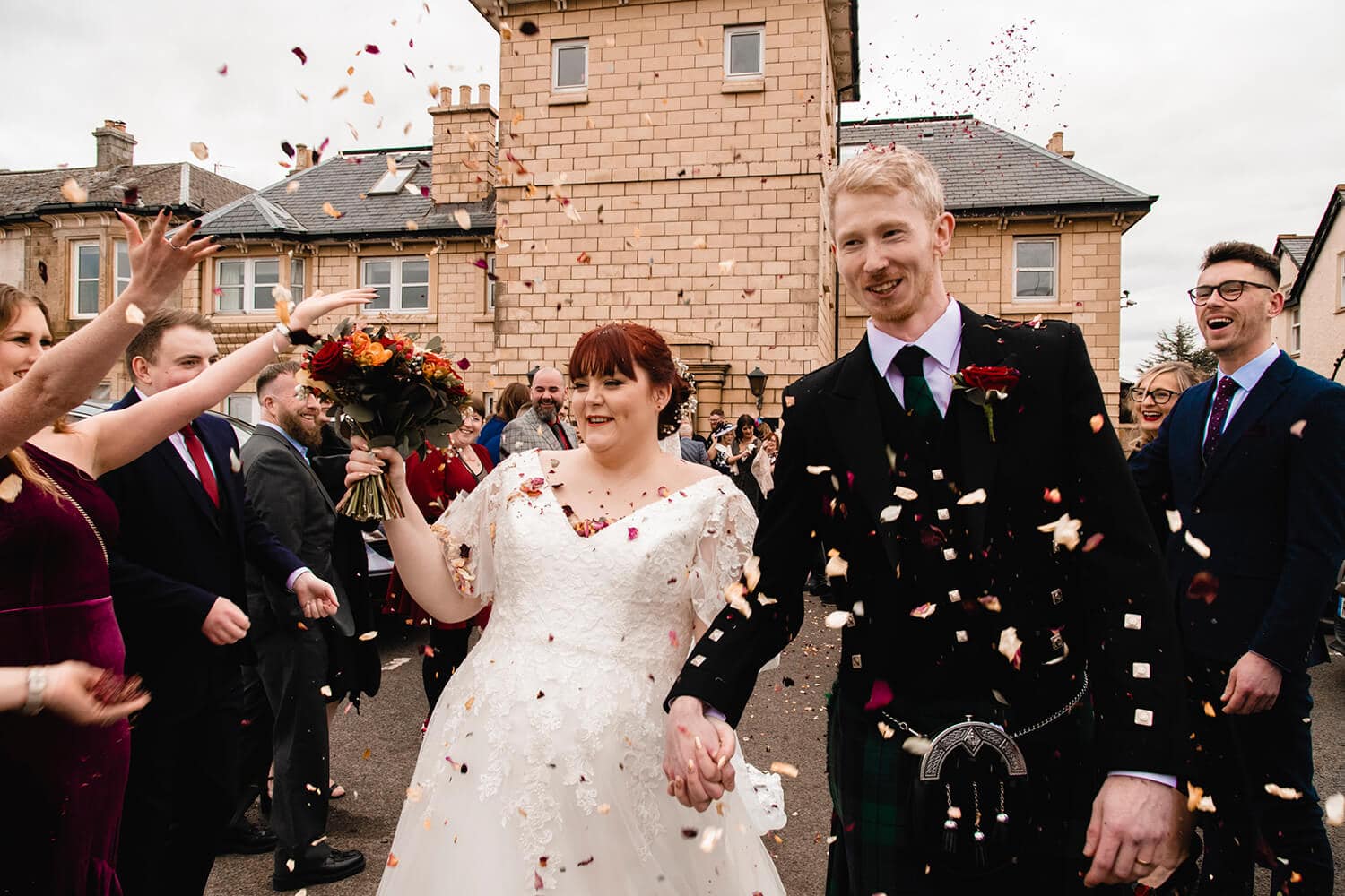 Bride and groom walking throhg shower of confetti outside Fairfield Hotel Ayr by Ayrshire wedding photographer Richard Campbell